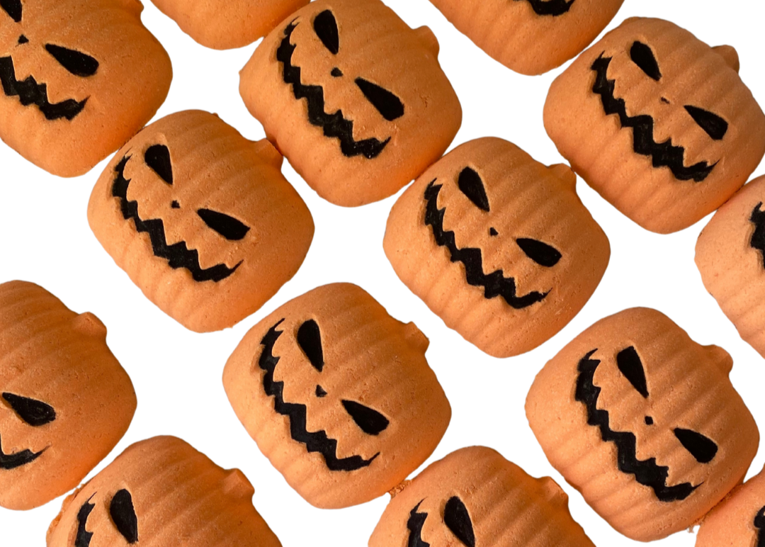 Pattern of small pumpkins with jack-o'-lantern faces on a bath bomb white background